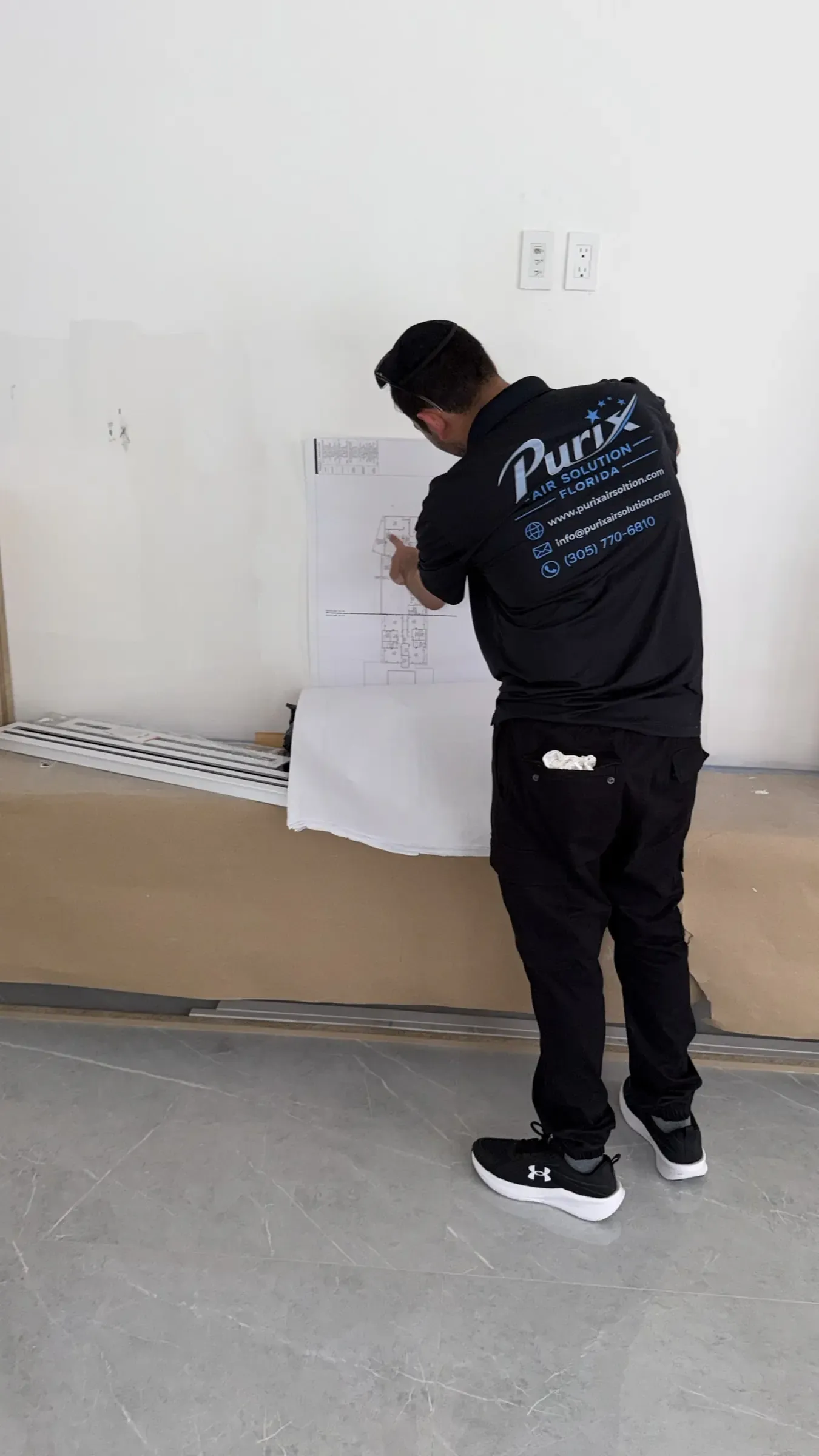 Purix technician reviewing ductwork plans on site